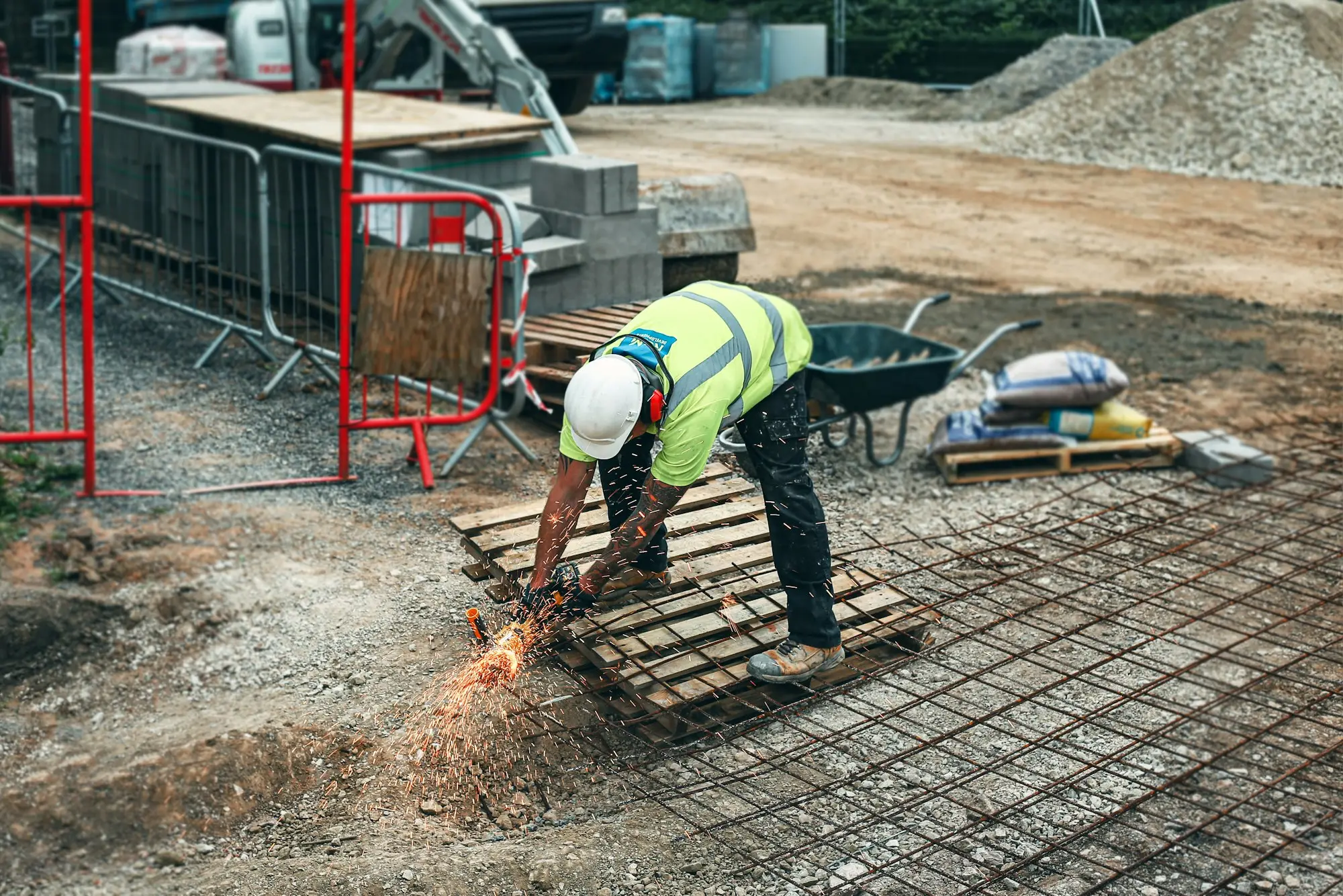 Builder on a construction site checking plans against the clock
